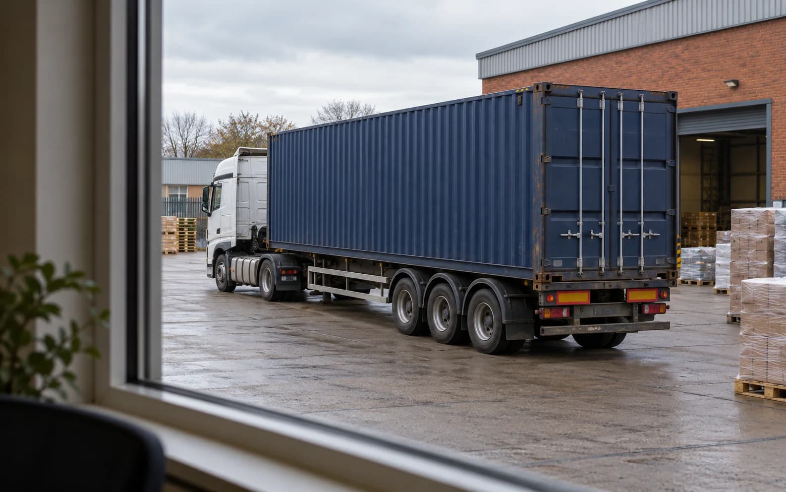 Container trailer in a distribution yard viewed from a freight office.
